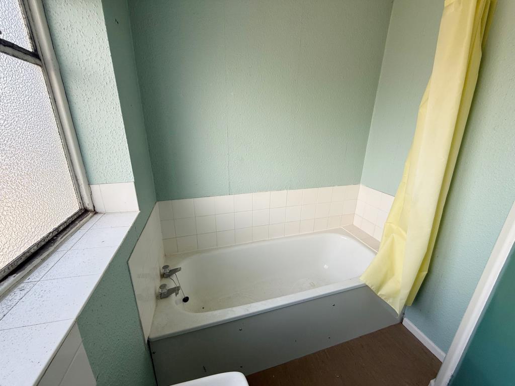 Lot: 109 - FIRST AND SECOND FLOOR THREE-BEDROOM MAISONETTE - Bathroom with white tiles and painted walls